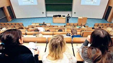 Eine Dozentin steht im Hörsaal vor Studierenden.