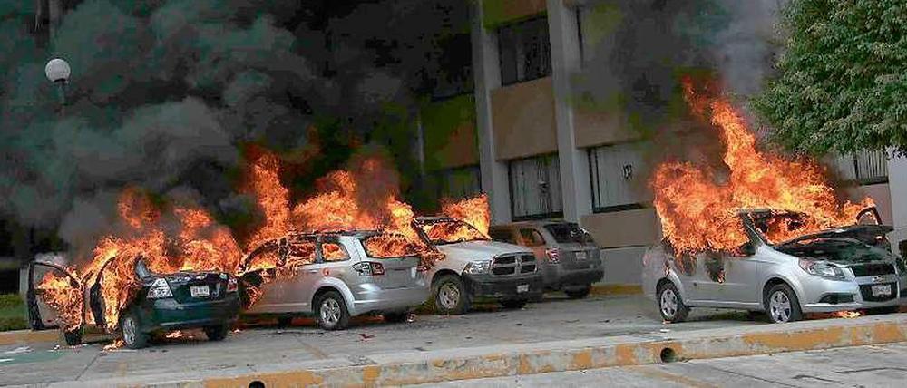 Brennende Autos außerhalb des Regionalparlaments des Bundesstaats Guerrero in Mexiko. Aufgebrachte Demonstranten zündeten später auch das Gebäude an.