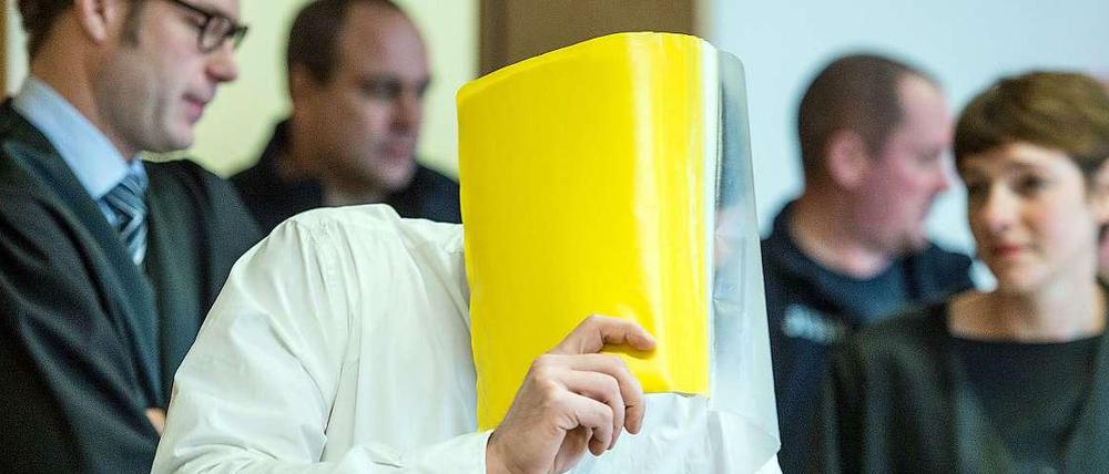 Mit Hefter als Schutz: der Angeklagte Mario K. vor dem Landgericht in Frankfurt Oder.