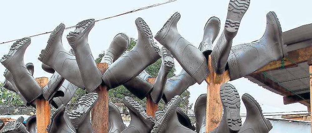 Epidemie-Skulptur. Die Gummistiefel der medizinischen Helfer vor einer ETU in Monrovia.