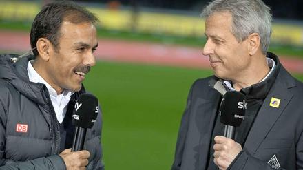 Jos Luhukay und Lucien Favre stehen nebeneinander mit Mikrofonen in der Hand.