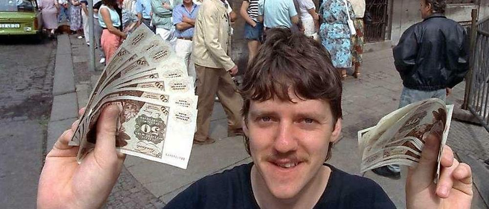 Ein DDR-Bürger holt sich am 1.Juli 1990 die erste Handvoll D-Mark ab.