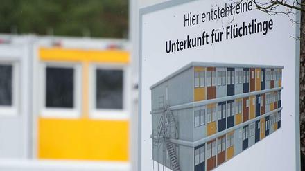 Ein Schild zeigt an, wo eine Unterkunft für Flüchtlinge entsteht.