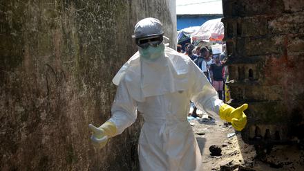 Rotes Kreuz-Helfer tragen in Monrovia, Liberia, natürlich noch die volle Schutzkleidung. Dennoch sollen die Schulen in dem schwer von Ebola betroffenen Land im Februar wieder öffnen.