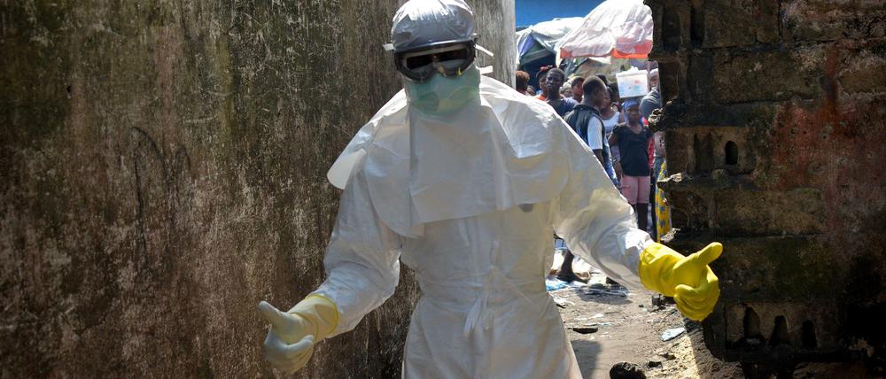 Rotes Kreuz-Helfer tragen in Monrovia, Liberia, natürlich noch die volle Schutzkleidung. Dennoch sollen die Schulen in dem schwer von Ebola betroffenen Land im Februar wieder öffnen.