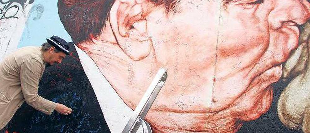 Die Kritzeleien müssen weg: Maler Dimitri Vrubel hat sein Bild „Bruderkuss“ zuletzt im April 2014 gereinigt. Mit der Aufnahme in die Stiftung Berliner Mauer wäre nicht nur die aktuell nötige Reinigung finanziell gedeckt.