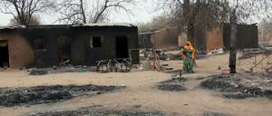 Eine Frau geht durch die Ruinen des umkämpften Ortes Baga im Nordosten von Nigeria. Das Foto ist ein Archivbild von 2013, doch am Wochenende wütete die islamistische Sekte Boko Haram erneut in Baga und Umgebung. Der Ort soll niedergebrannt sein, berichten Augenzeugen.