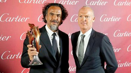 Preisregen. Der mexikanische Filmemacher Alejandro González Inárritu (l.) hält seinen Preis als Regisseur des Jahres beim Filmfestival in Palm Springs in die Höhe, am 3. Januar. An seiner Seite "Birdman"-Hauptdarsteller Michael Keaton: Die Broadway-Komödie über einen abgehalfterten Superhelden-Star, der ein Comeback auf der Bühne versucht, ist einer der Oscar-Favoriten. Deutscher Filmstart: 29. Januar. 