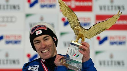 Stefan Kraft jubelt mit dem Siegerpokal in der Hand.
