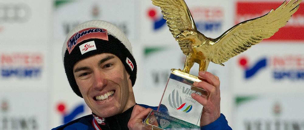 Stefan Kraft jubelt mit dem Siegerpokal in der Hand.