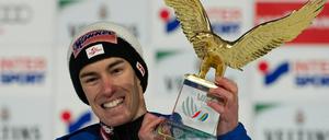 Stefan Kraft jubelt mit dem Siegerpokal in der Hand.