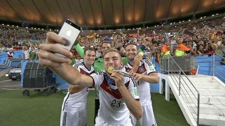 Blödsinn, der um die Welt geht. Nicht alle Selfies sind so harmlos wie das Foto, das Christoph Kramer von sich, Kevin Großkreutz (l.), Manuel Neuer (m.) und Shkodran Mustafi (r.) machte, während die frischgebackenen Weltmeister mit ihren Medaillen posieren.