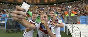 Blödsinn, der um die Welt geht. Nicht alle Selfies sind so harmlos wie das Foto, das Christoph Kramer von sich, Kevin Großkreutz (l.), Manuel Neuer (m.) und Shkodran Mustafi (r.) machte, während die frischgebackenen Weltmeister mit ihren Medaillen posieren.