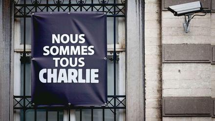Protest und Überwachung. Am Fenster eines Hauses im belgischen Mons, an dem eine Überwachungskamera angebracht ist, ist die Botschaft "Wir alle sind Charlie" zu lesen.