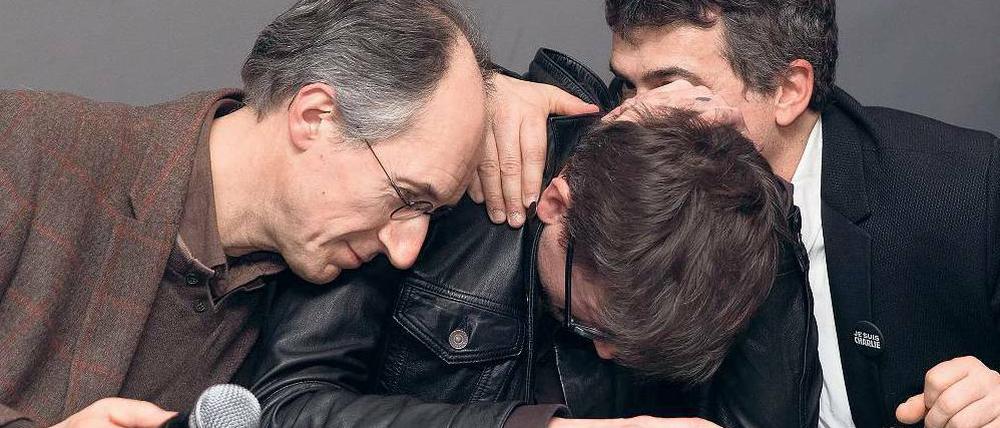 Der neue Chefredakteur von „Charlie Hebdo“ Gerard Briard (links) und der Kolumnist Patrick Pelloux (rechts) mit Luz, dem Zeichner der Titelseite des neuen Heftes, während der Pressekonferenz in den Räumen der „Liberation“.
