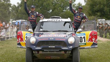 Nasser Al-Attiyah (r.) und sein französischer Co-pilot Matthieu Baumel (l.) feiern im Zielbereich der letzten Etappe ihren Gesamtsieg.
