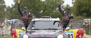 Nasser Al-Attiyah (r.) und sein französischer Co-pilot Matthieu Baumel (l.) feiern im Zielbereich der letzten Etappe ihren Gesamtsieg.