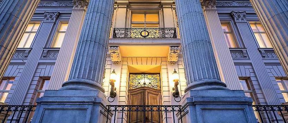 Das Berliner Kronprinzenpalais im Schatten des Abends und einer erleuchteten Eingangstür