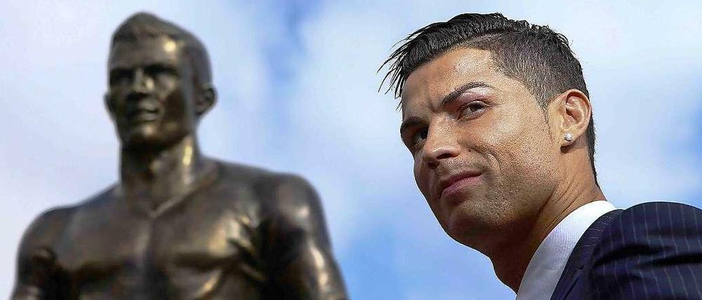 Der Weltfußballer 2015 Christiano Ronaldo vor einer Statue auf Madeira (Portugal) , die ihn selbst zeigt.