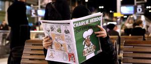 Ein Mann liest am Gare de Lyon in Paris die neueste Ausgabe von "Charlie Hebdo".