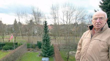 Grenzkonflikt. Wolfgang Paul auf dem Dach seines Hauses mit Blick auf den Grenzstreifen hinter seinem Garten.