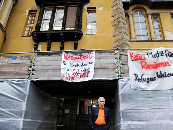 Rainer Leppin vor seiner Schule, die nicht nur auf die eigenen Belange aufmerksam macht, sondern auch politisch engagiert ist, wie das Plakat rechts belegt.