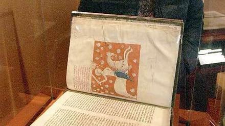 Eine Frau betrachtet 2010 eine originalgetreue Kopie des "Jakobsbuchs" in Santiago de Compostela, Spanien. Das Original des mittelalterlichen Reiseführers für Pilger auf dem Jakobsweg war im Juli 2011 aus der Kathedrale von Santiago de Compostela im Nordwesten Spaniens entwendet worden.