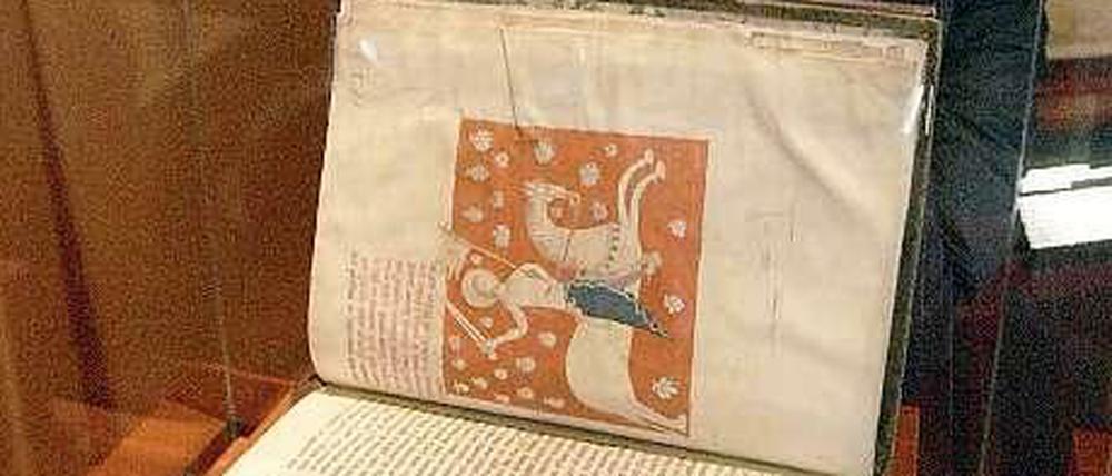 Eine Frau betrachtet 2010 eine originalgetreue Kopie des "Jakobsbuchs" in Santiago de Compostela, Spanien. Das Original des mittelalterlichen Reiseführers für Pilger auf dem Jakobsweg war im Juli 2011 aus der Kathedrale von Santiago de Compostela im Nordwesten Spaniens entwendet worden.