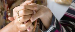 Eine Therapeutin hält im Hospiz St. Martin in Stuttgart die Hand einer todkranken Bewohnerin.