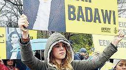 Weltweiter Protest gegen die Auspeitschung von Raif Badawi. Eine Demonstrantin hält ein Plakat vor der saudischen Botschaft in Den Haag hoch.
