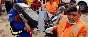 Indonesische Sicherheitskräfte mit einem Sitz aus der abgestürzten AirAsia-Maschine. 