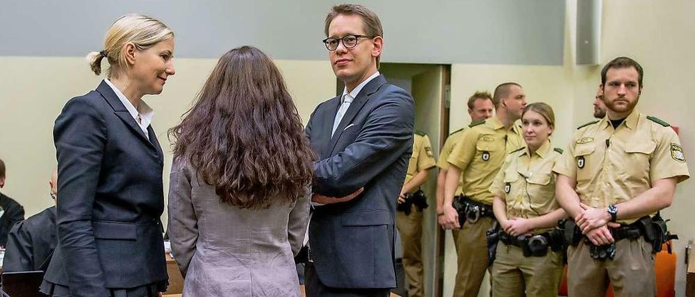 Die Angeklagte Beate Zschäpe (M) steht am 20.01.2015 im Gerichtssaal des Oberlandesgerichts in München (Bayern) zwischen ihren Anwälten Anja Sturm (l) und Wolfgang Heer (r) zu sehen.