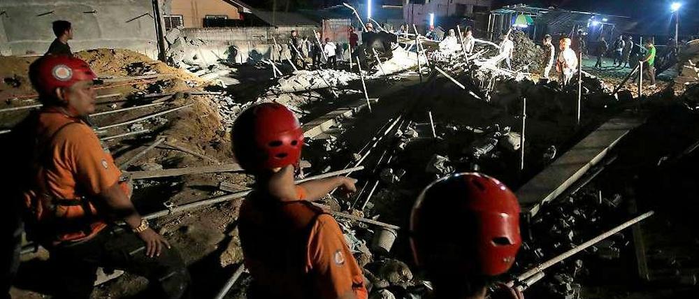 Philippinische Rettungskräfte suchen in der eingestürzten Werkshalle nahe der Hauptstadt Manila nach Leichen.