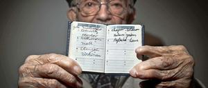 Hy Abrams, Überlebender, hat in einem Büchlein die Namen der Konzentrationslager eingetragen, in denen er von den Nazis inhaftiert worden war.