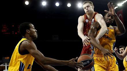 Galatasarays Martynas Pocius (Mi.) kämpft gegen Albas Alex Renfroe (li.) und Jamel McLean (re.) um den Ball.