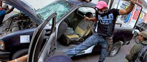 Wütende Demonstranten zerstören ein Polizeifahrzeug in Mexiko. Sie protestieren gegen den Tod linker Studenten im Auftrag von Politikern.