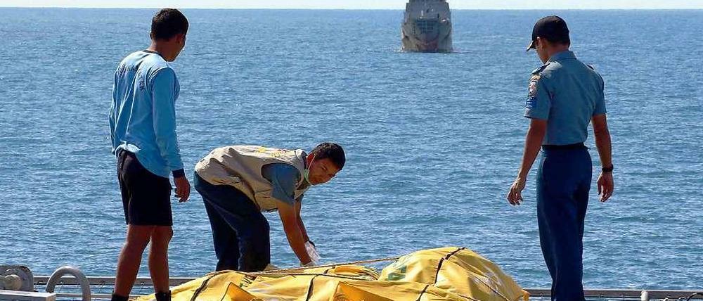 Rettungskräfte in Indonesien sichern Leichensäcke. Das Flugzeug mit der Nummer AirAsia QZ8501 war am 28. Dezember in die Javasee gestürzt.
