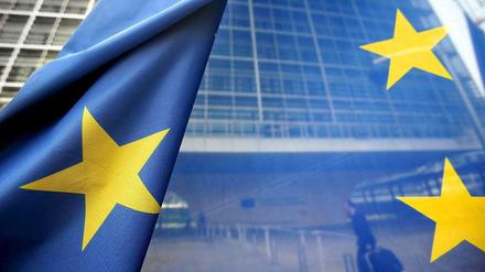Und sie leuchten doch: Europas Sterne auf einer Flagge, im Hintergrund die Europäische Kommission in Brüssel.