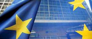 Und sie leuchten doch: Europas Sterne auf einer Flagge, im Hintergrund die Europäische Kommission in Brüssel.