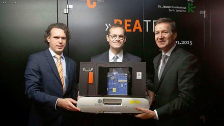 Männer und Technik. Tobias Dreißigacker, Michael Müller und Michael Geißler (v.l.) mit einem Modell vor dem echten Blockheizkraftwerk im St. Joseph Krankenhaus.