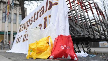 Eine Tasche mit der Aufschrift "Köln" steht vor einem Plakat mit der Aufschrift "Keupstraße ist überall", das vor dem Oberlandesgericht in München an Absperrgittern angebracht ist. Am 9. Juni 2004 explodierte in der Keupstraße in Köln eine vom NSU gezündete Nagelbombe.