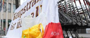 Eine Tasche mit der Aufschrift "Köln" steht vor einem Plakat mit der Aufschrift "Keupstraße ist überall", das vor dem Oberlandesgericht in München an Absperrgittern angebracht ist. Am 9. Juni 2004 explodierte in der Keupstraße in Köln eine vom NSU gezündete Nagelbombe.