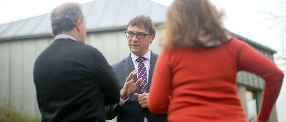 Der Präsident der Evangelischen Kirche in Hessen und Nassau, Volker Jung, unterhält sich in Groß-Gerau mit einer iranischen Familie. Jung besuchte die Flüchtlingsfamilie im Kirchenasyl. Das Bild ist im Dezember entstanden.