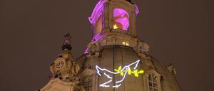 Eine Friedenstaube ist am 26.01.2015 an der Kuppel der Frauenkirche nahe der Bühne während eines Konzerts für Weltoffenheit und Toleranz auf dem Neumarkt in Dresden (Sachsen) zu sehen.
