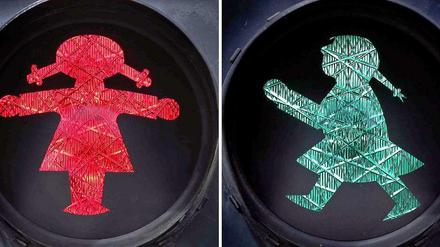 Eine rot (l) und eine grün leuchtende Ampelfrau an einer Fußgängerampel in Sonthofen (Bayern).