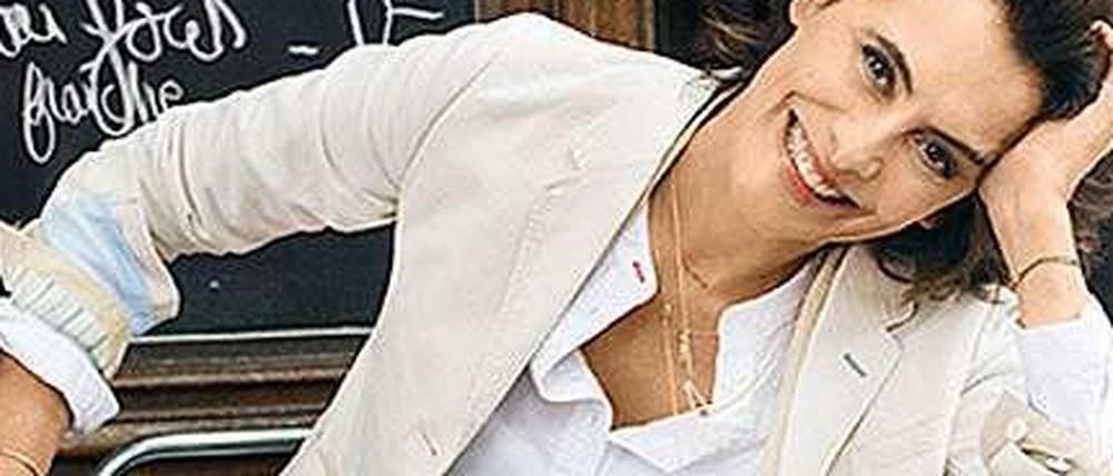 Inès de la Fressange vor einem Pariser Bistro in Kleidung des japanischen Herstellers Uniqlo.