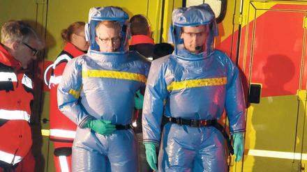 Gut geschützt. Mit Spezialanzügen kamen Feuerwehrmänner ins Urban-Krankenhaus, um den möglicherweise mit Ebola infizierten Mann zur Charité zu bringen.