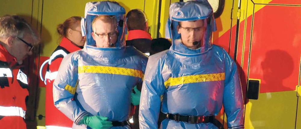 Gut geschützt. Mit Spezialanzügen kamen Feuerwehrmänner ins Urban-Krankenhaus, um den möglicherweise mit Ebola infizierten Mann zur Charité zu bringen. 