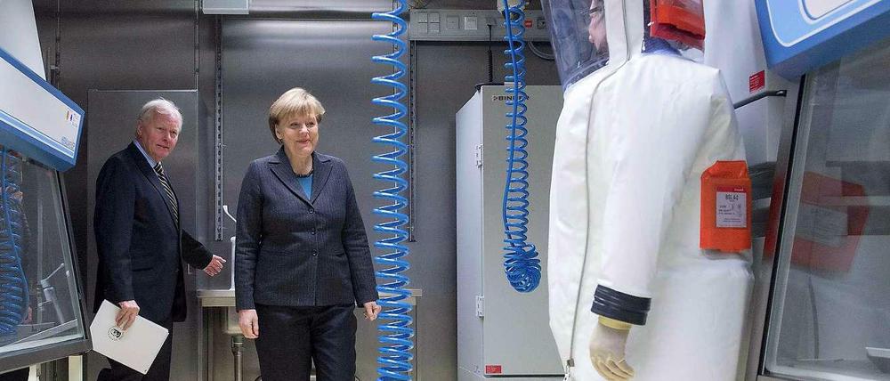 Hoher Besuch. RKI-Präsident Reinhard Burger führt Bundeskanzlerin Angela Merkel durch das neu eröffnete Hochsicherheitslabor.