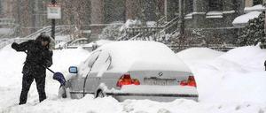 Ein Mann in Boston befreit sein Auto vom Schnee.